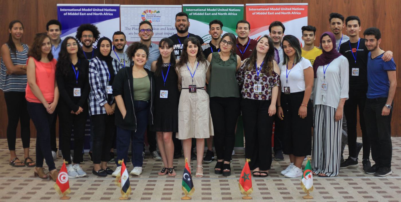 Forum participants in a group photo with the flags of North African countries