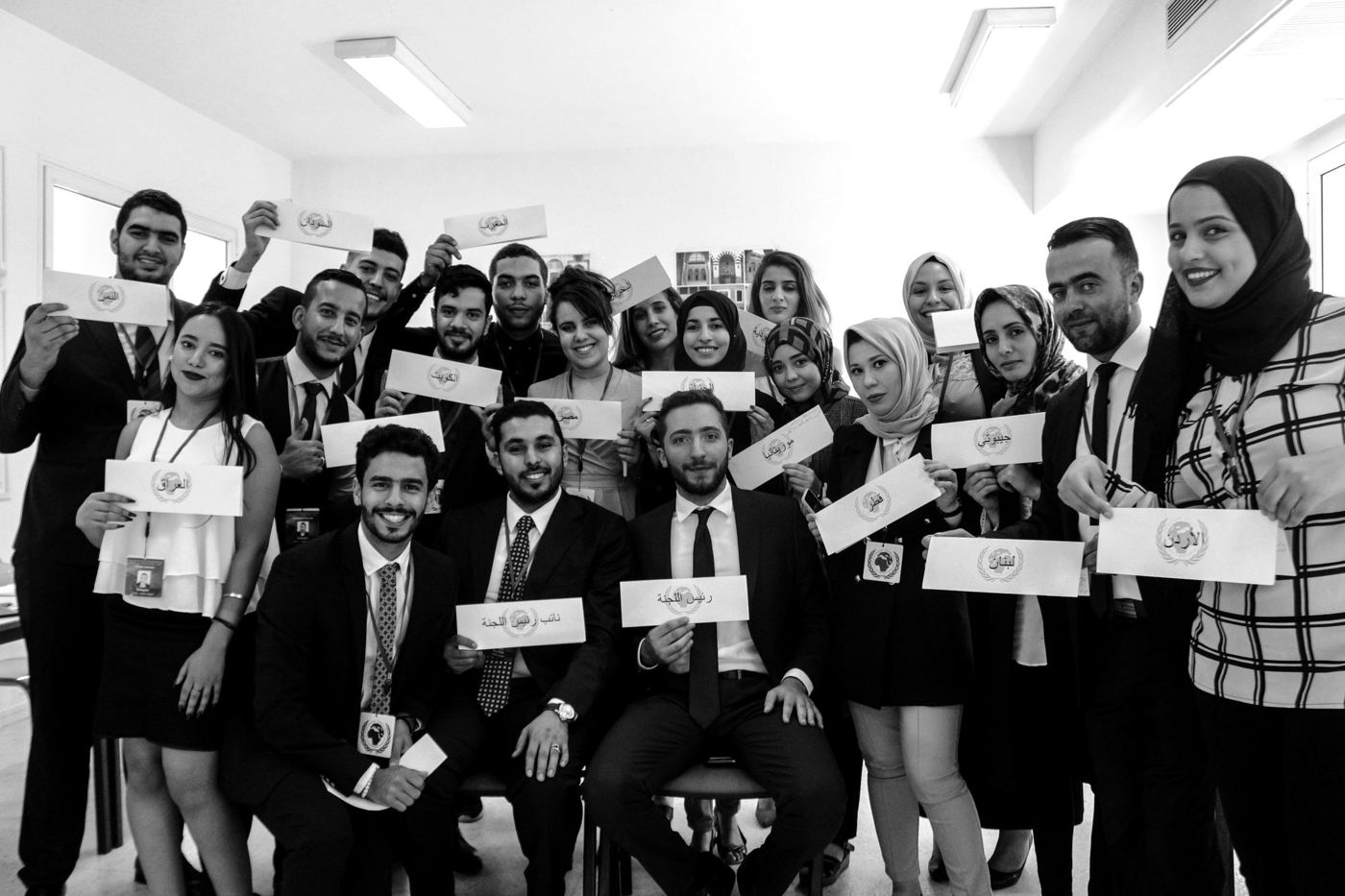 Black-and-white group photo of delegates holding name cards