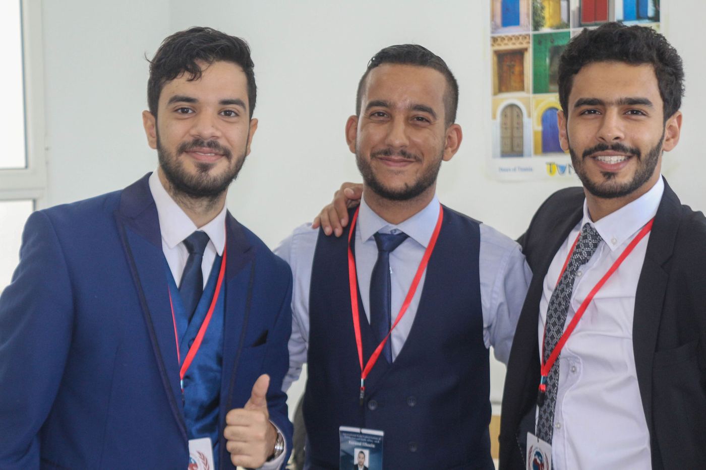 Three participants smiling with their conference badges