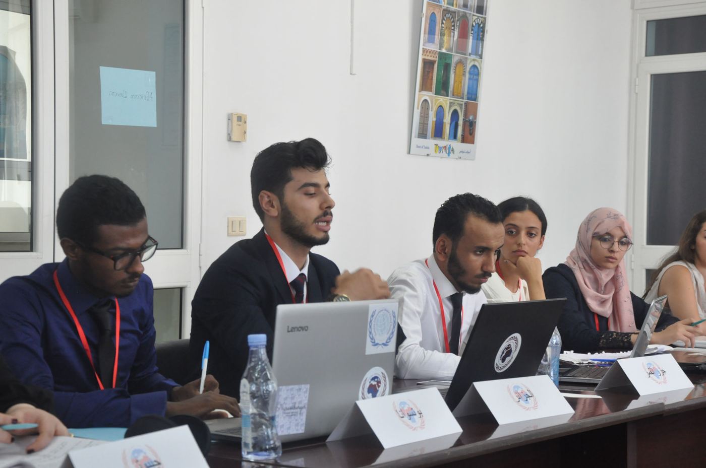 Participants at desks with laptops and name cards