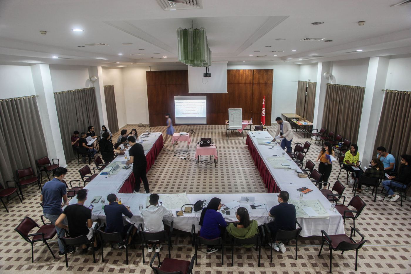 Participants seated around a long table in the forum hall