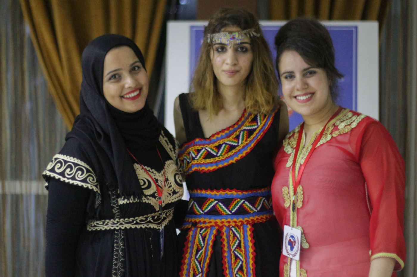 Three participants in traditional dress at the cultural evening